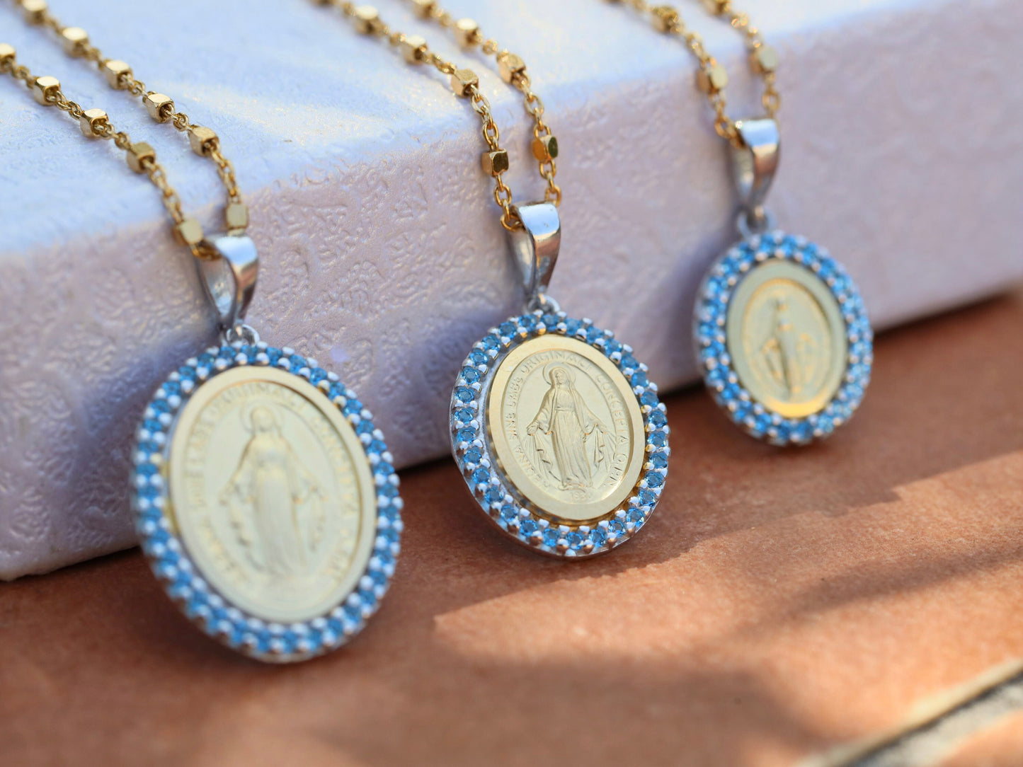 Medalla Milagrosa, plata de ley 925 bañada en oro de 18k, medalla ovalada con circonita azul, finos detalles Medalla Nuestra Señora de Gracia en latín